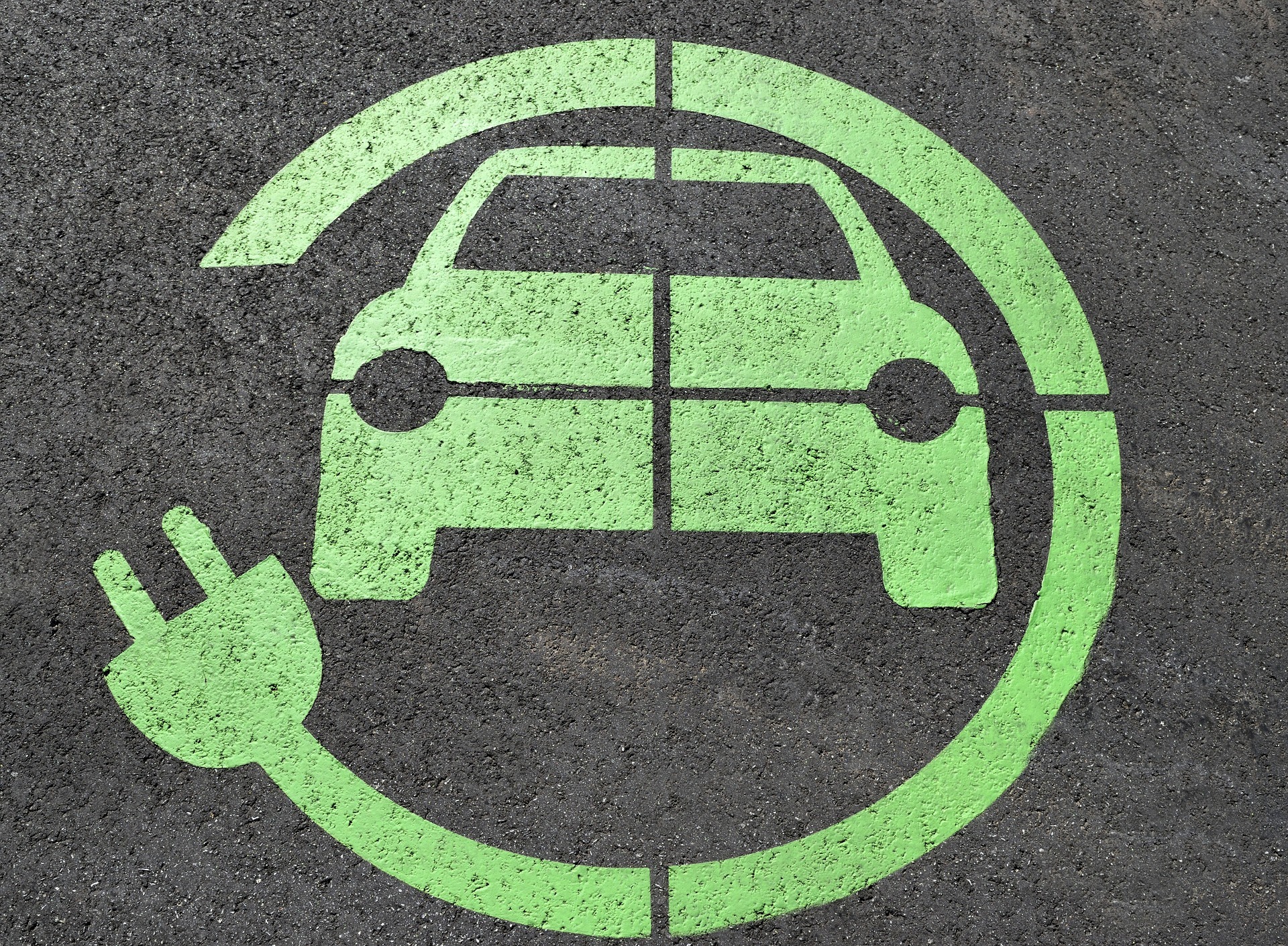 A photograph of an electric vehicle symbol on the road
